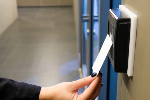 Women hand reaching to use RFID key card to access to office building area and workspace. In building security only for authorized person